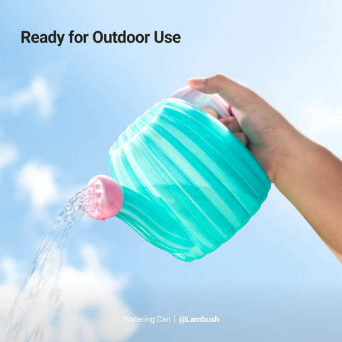 Hand holding a turquoise watering can outdoors, ready for outdoor use with water pouring from the spout.
