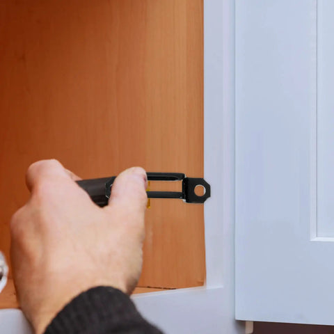 Person installing a 100 Piece Invisible Connector Screw for hidden furniture fasteners in cabinet assembly.