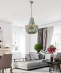 Three Light Wood Beaded Chandelier in Rustic Farmhouse Vibe hanging in modern living room with white beaded shade.