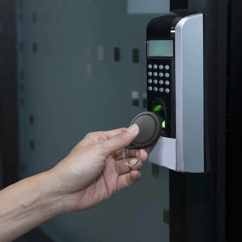 Hand using Dope 100 Pcs 13.56MHz UID Keyfobs for access control on electronic door reader