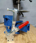 Badass Heavy Duty Vertical Toggle Clamps 10 Pack secured on a blue workbench vise, showcasing robust clamp design for woodworking.