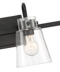 Close-up of the Inwood 4 Light Bathroom Vanity Light Fixture in Chrome With Blown Clear Glass Shades showing one bulb and part of the black backplate.