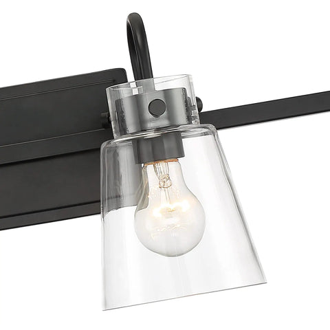 Close-up of the Inwood 4 Light Bathroom Vanity Light Fixture in Chrome With Blown Clear Glass Shades showing one bulb and part of the black backplate.
