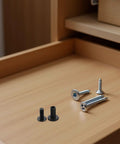 Close-up of 40 Sets Furniture Connector Bolts with M3 hex socket screws and barrel nuts for knock down fasteners on wooden surface