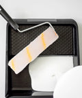 No Sweat Replacement Paint Roller Sleeve Covers for Silky Smooth Interior Wall Coatings in paint tray with white paint.