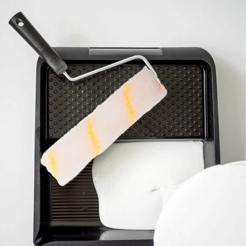 No Sweat Replacement Paint Roller Sleeve Covers for Silky Smooth Interior Wall Coatings in paint tray with white paint.