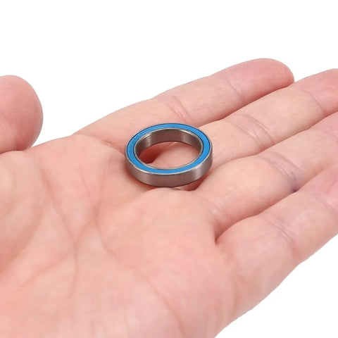 Single bearing from Blue Sealed Ball Bearing Kit, 26Pcs Full Set For RC Cars, precision machined for Granite Senton Typhon BLX 3S shown in hand.