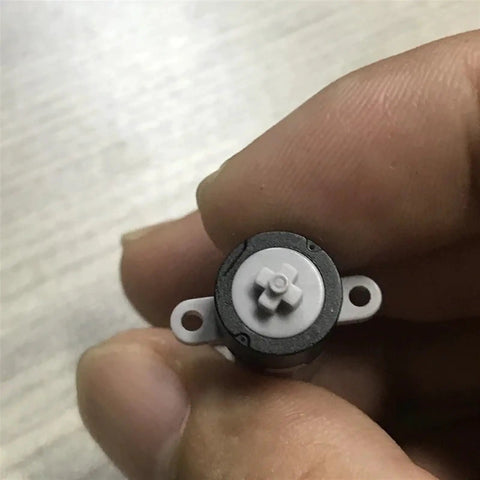 Close-up of DC Planetary Gear Motor Dope Compact 3V 5V 6V 120RPM High Torque 8mm By 10mm Shaft M10 Reducer held between fingers