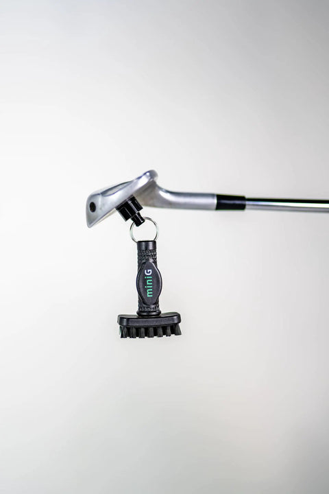 Mini Golf Brush With Detachable Magnet And Heavy Duty Nylon Bristles hanging on golf club for quick clubface and groove cleaning