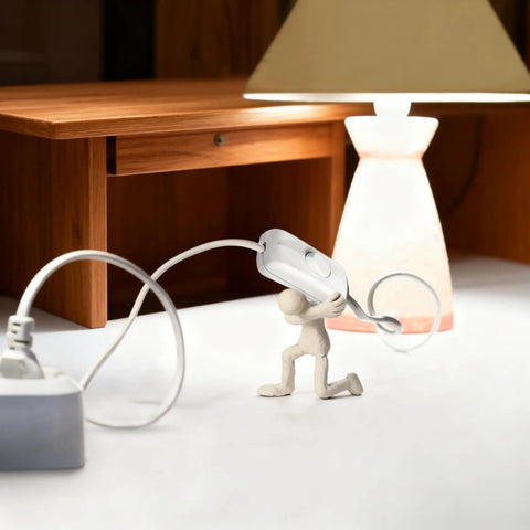 White Thumb-Control Inline Power Button Switch For Lamps And Small Devices Dual Pole AC Handles 12V To 250V Up To 2A Quick Wire Connect Safe Housing Perfect DIY Light Fix For Home Or Office in use on a desk with lamp.