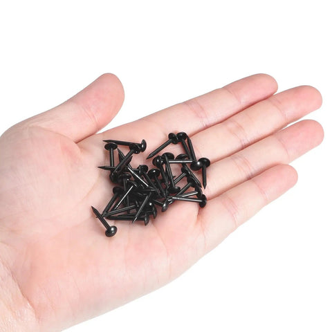 Level Up Your Furniture Game With These Rock Solid Black Carbon Steel Upholstery Tacks 50 Pack Smooth Grip Thumb Pin Nails in a hand.