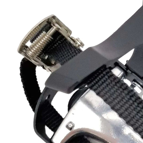 Close-up of adjustable webbing strap on bike pedals with toe clips and straps for indoor cycling, non-slip surface, 14mm axle, 9/16 thread.