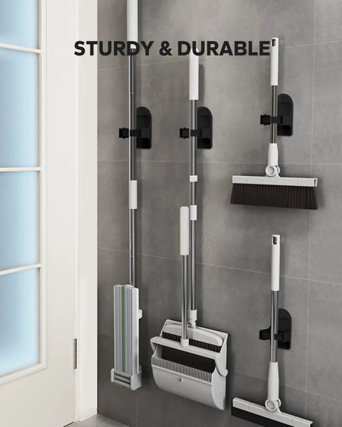 Beefy Heavy Duty Broom Holder Wall Mount Set Of 4 Black Metal Bracket for Brooms and Mops Organizer installed on grey tiled wall.