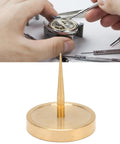 Watch Balance Wheel Bracket Copper Holder For Repairs, tool on workbench with hands and watch components, close-up view