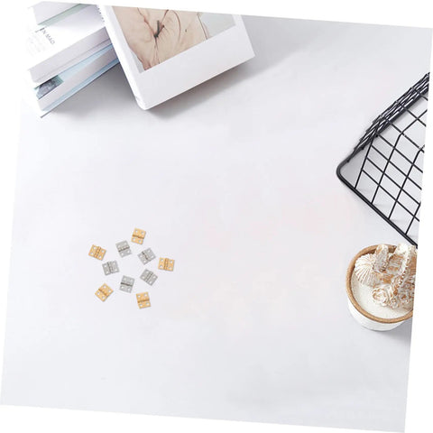Copper Mini Hinges For Craft Projects And Jewelry Boxes, 100 Pack displayed on a white surface with decor items nearby
