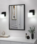Chill Out Matte Black Milk Glass Wall Sconces Bringing Soft Warm Light To Your Space Premium Metal Build Rust Resistant Finish, illuminated beside a mirror.