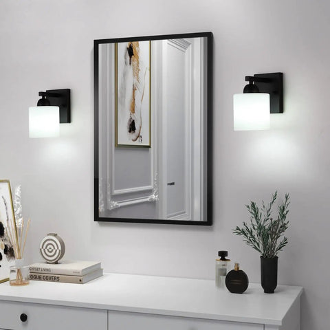 Chill Out Matte Black Milk Glass Wall Sconces Bringing Soft Warm Light To Your Space Premium Metal Build Rust Resistant Finish, illuminated beside a mirror.