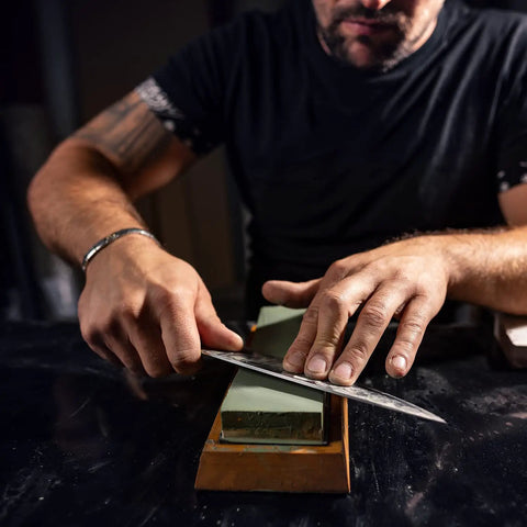 Man sharpening knife using Two Sided Whetstone Knife Sharpener With 1000 And 6000 Grit Wet Stone Kit For Kitchen Knives.