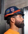 Construction worker wearing safety gear and helmet with Skribes Fine Tip Permanent Marker 12 Pack For Worksite And Multi Surface Use Black Ink