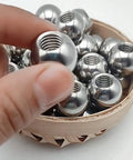 Stainless steel threaded piercing balls (M8) with internal threads, set of several, 15–60 mm, in wooden bowl
