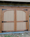 Installed wooden barn doors with black wrought iron 8 Inch T Strap Barn Door Hinges Heavy Duty Gate Hinge Set, rustproof design