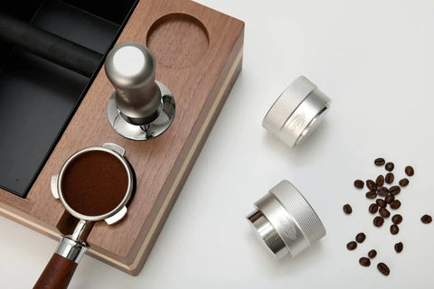 53mm Gravity Adaptive Espresso Distributor for 54mm Portafilters shown with coffee grounds and beans, 304 stainless steel.