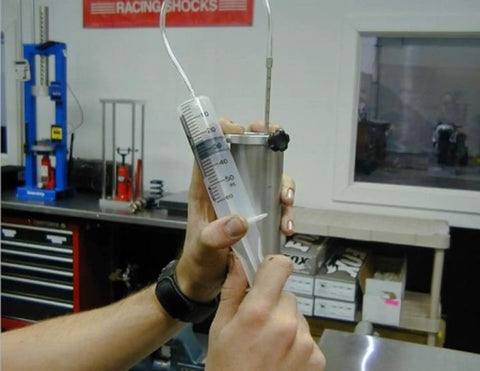 Universal Inverted Fork Service Tool Kit With oil level gauge and syringe in action for suspension maintenance