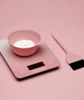 Digital Hair Color Scale For Precise Weighing Of Dyes And Developer with pink bowl and brush on pink background