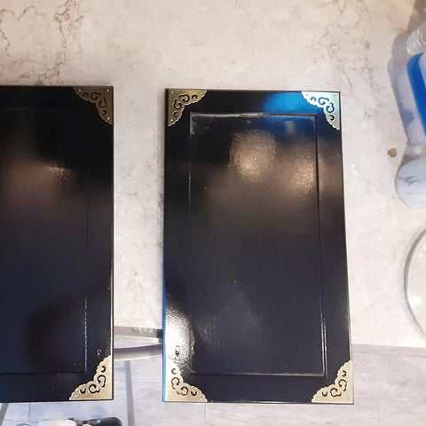 Two Point Five Inch Four Piece Antique Brass Corner Brackets For Furniture Edge Guarding And Vintage Home Decor Makeover featuring shiny brass accents on black furniture edges.