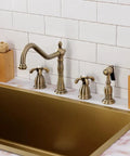 French Country Widespread Kitchen Faucet With Brass Sprayer in Oil Rubbed Bronze installed over a gold sink