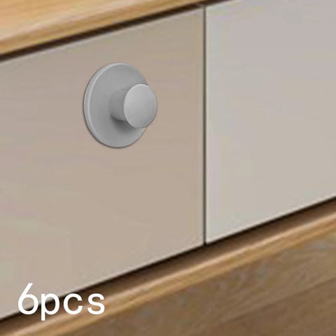 Close-up of Stick-On Cabinet Pulls 6 Pack, Self-Adhesive Knob Handles installed on a gray cabinet door.
