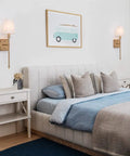 Sleek Modern Wall Sconces in Antique Brass Brush Finish With White Fabric Shade above bed in bedroom