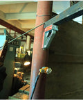 Front view of 600A magnetic welding ground clamp with switchable magnet holder mounted on pipe, welding cable attached.