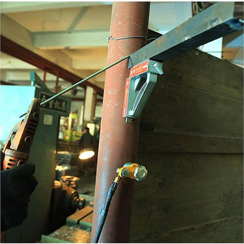 Front view of 600A magnetic welding ground clamp with switchable magnet holder mounted on pipe, welding cable attached.