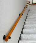Top Shelf Solid Wood Stair Banister Handrail With Anti Slip Pine Railing mounted on wall alongside marble staircase.