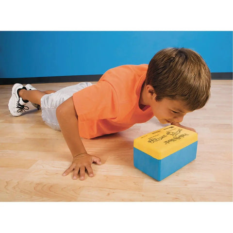 Young boy using Unbreakable Soft Foam Push Up Block For Proper Form Training Learn To Stop On Contact And Push Back Up Perfect For Home Gym Gains And PT Sessions This 8 Inch By 5 Inch Block Elevates Pushups And Reduces Strain on wooden floor.