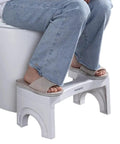 Person using Foldable Toilet Stool Foot Rest Made For Real Squat Posture 7.5 Inch White Bathroom Hack To Ease Straining And Beat Constipation Sturdy ABS Build Portable Squatting Potty For Home