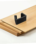 Close-up of a black plastic fastener for Six Pack Outdoor Sofa Clips For Rattan Wicker Sectional Couches on a wooden deck.
