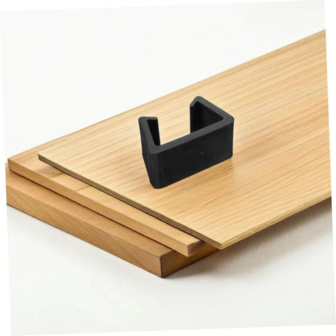 Close-up of a black plastic fastener for Six Pack Outdoor Sofa Clips For Rattan Wicker Sectional Couches on a wooden deck.