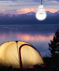 Two Pack USB LED Camping Light Bulbs With 8.2 Ft Extra Cord Tent Lantern glowing above a tent at sunset by a lake.