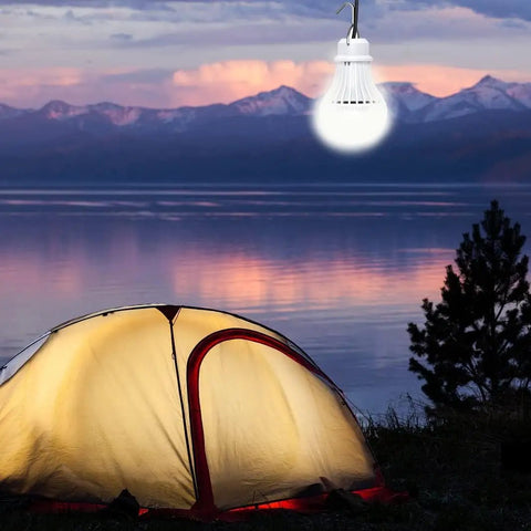 Two Pack USB LED Camping Light Bulbs With 8.2 Ft Extra Cord Tent Lantern glowing above a tent at sunset by a lake.