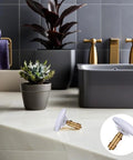 Copper Pop up Bathtub Plug with Bounce Design for Drain Hole placed near a modern bathtub and potted plant in stylish bathroom.