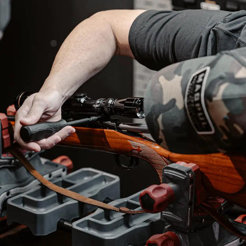 Person using No Sweat 89 Piece Gunsmithing Screwdriver Set With Hollow Ground Bits And Textured Rubber Drivers on rifle for maintenance.