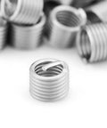 Heavy Duty Stainless Thread Repair Inserts Kit 100 Pieces M6x1.0x1.5D Locking Type Rock Solid Aircraft And Automotive Connections Durable 304 Stainless Steel Wire Sleeve, close-up of individual insert
