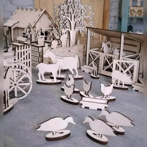 Laser-cut Baltic birch plywood farm animal shapes in natural wood on a workshop surface.