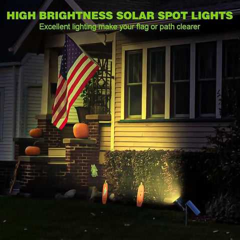 Solar Powered Outdoor Spot Lights 600LM Four Pack, Waterproof 18 Led Landscape Lighting illuminating a flag on a house at night