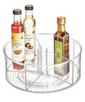 Recycled Plastic Lazy Susan Spin Turntable Organizer For Pantry And Bathroom, 11.5 Inch Clear, with divided sections holding bottles.
