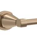 Close-up of a pivoting toilet paper holder in champagne bronze finish wall mount bathroom accessory durable corrosion resistant hardware that holds any sized roll easy replacing secure pivot arm for quick one handed change.