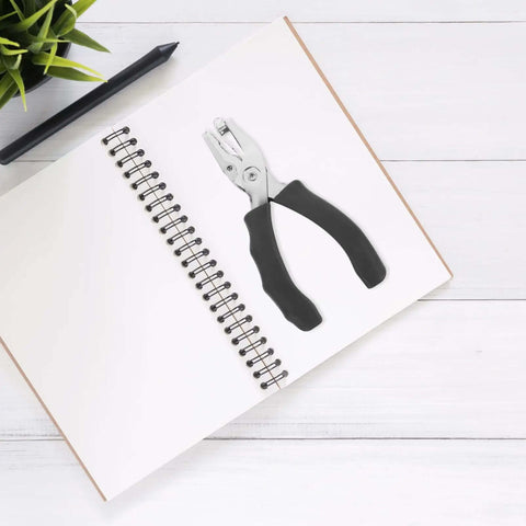Metal Single Hole Puncher With Ergonomic Handles And Built In Guide For Home Office Crafts on a notebook