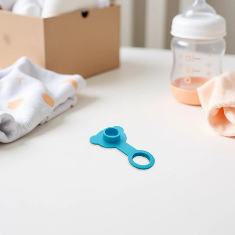 Blue Silicone Bathtub Drain Stopper Leakproof for Bath Tubs, bear-shaped plug on table with baby items, water-resistant material.